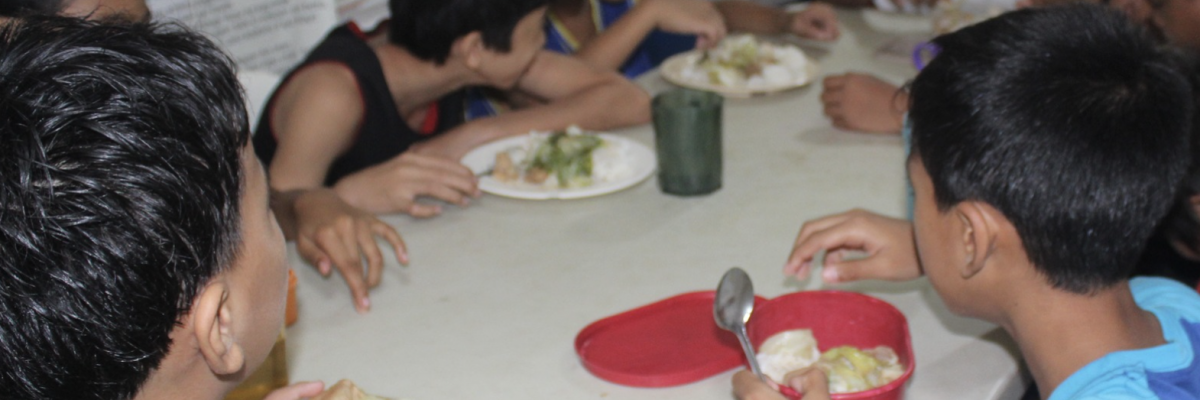 Repas collectif pour enfants dans une mission de nutrition communautaire avec Globalong Enfants partageant un repas équilibré dans le cadre d’un programme nutritionnel Globalong