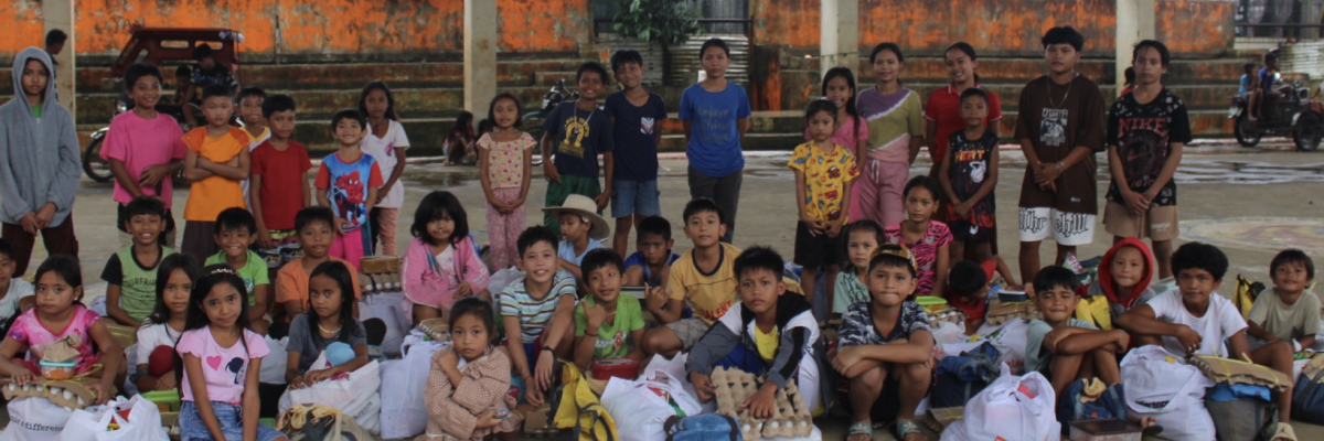 Distribution de denrées aux enfants dans une mission de lutte contre la malnutrition avec Globalong Groupe d’enfants recevant des dons alimentaires dans le cadre d’une mission nutritionnelle Globalong