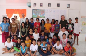 Volontaires internationaux et élèves d'une école rurale aux Philippines posant ensemble dans une salle de classe