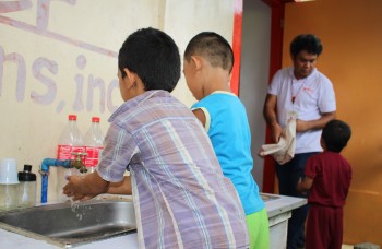 Atelier d’hygiène pour enfants dans un centre d’accueil aux Philippines - Globalong Enfants apprenant à se laver les mains dans un centre éducatif, accompagnés d’un encadrant local - Globalong