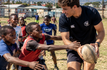 Participant encadrant des enfants pendant une activité de rugby en Afrique du Sud