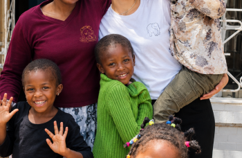Bénévole Globalong accompagnant un enfant lors d'une activité dans un centre d'accueil en Tanzanie
