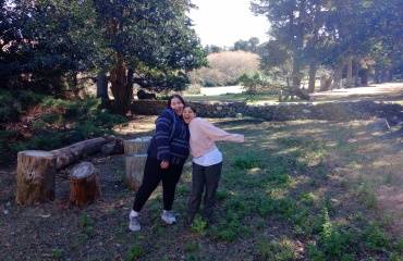 Deux volontaires de Globalong souriantes et posant joyeusement dans un cadre naturel, entourées d'arbres et de verdure.