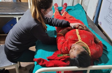 Bénévole Globalong en mission d’ostéopathie au Népal prodiguant des soins dans un centre médical rural Mission de bénévolat en ostéopathie au Népal – une bénévole Globalong apporte des soins manuels à une patiente dans un centre de santé local
