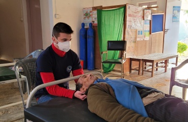 Volontaire Globalong en mission d’ostéopathie au Népal soignant un patient dans un centre de santé rural Mission de bénévolat en ostéopathie au Népal – un volontaire Globalong réalise un soin ostéopathique sur un patient dans un hôpital rural