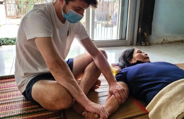 Volontaire Globalong en mission d’ostéopathie au Népal pratiquant des soins manuels auprès d’une patiente Mission de bénévolat en ostéopathie au Népal – un volontaire Globalong effectue une séance de soins manuels avec une patiente allongée