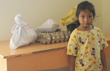 Petite fille bénéficiaire d’une mission nutritionnelle Globalong avec des provisions alimentaires