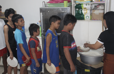 Enfants faisant la queue pour recevoir un repas chaud dans une mission nutritionnelle Globalong