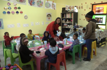 Volontaire Globalong animant une activité pédagogique avec des enfants San dans une salle de classe colorée en Namibie, dans le cadre d’un projet d’enseignement solidaire.