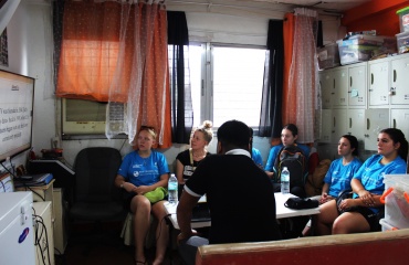 Des volontaires internationaux assistent à une session d’orientation dans une salle avec un coordinateur local aux Philippines