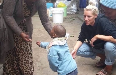 Bénévole participant à une activité de motricité avec un jeune enfant à Arusha