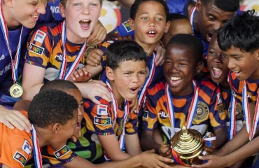 Groupe de jeunes jouant au football sur un terrain à Hout Bay