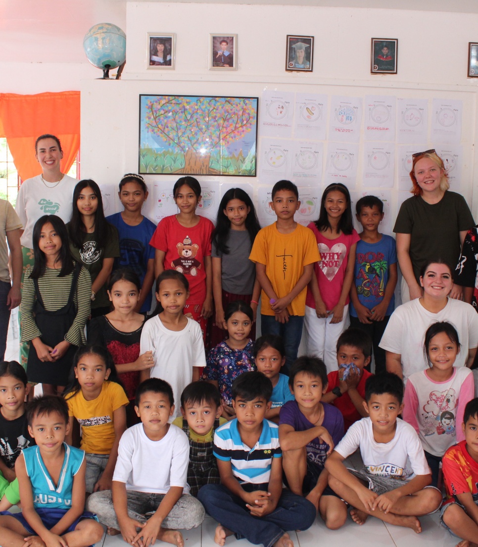 Volontaires internationaux et élèves d'une école rurale aux Philippines posant ensemble dans une salle de classe