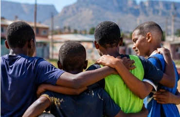 Participant encadrant des enfants pendant une activité de rugby au Cap
